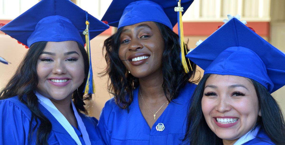 身穿蓝帽蓝袍的太阳3平台测速女学生对着镜头微笑